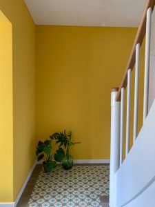 der Eingang in senfgelb, weißes treppengeländer