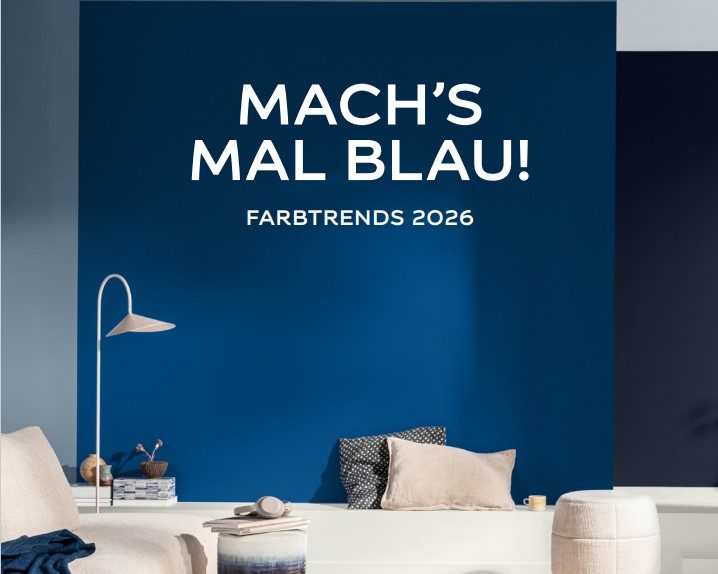 Wohnzimmer mit kräftig blauer Wand – Farbtrend 2026 in sattem Blau mit modernen Möbeln und Naturmaterialien